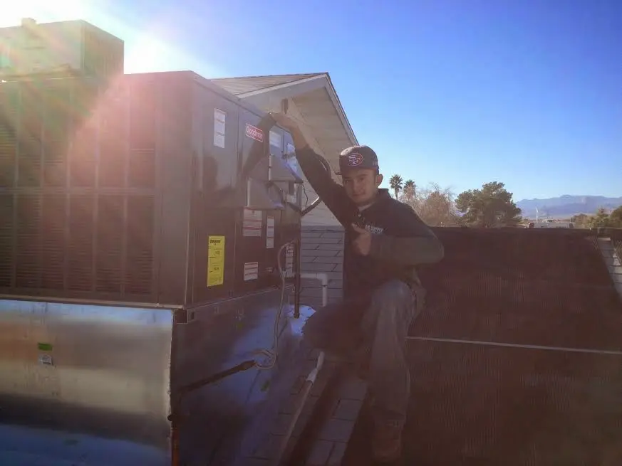 HVAC technician performing Air Duct Repair on a rooftop unit in Northumberland