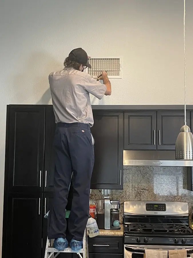 Technician inspecting an air vent during HVAC service in Northumberland